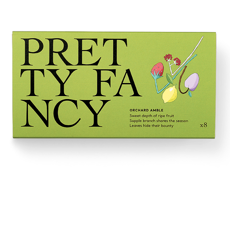 A green box packaging for Pretty Fancy chocolates with an illustration of a lemon and other fruits, indicating a variety of flavors.